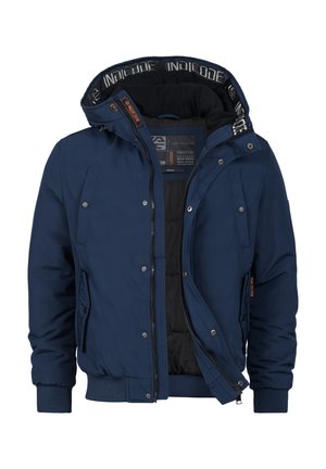 Chaqueta acolchada de color azul marino con capucha, que presenta un cierre de cremallera, bolsillos laterales y puños de canalé. Forrada con tela negra y con detalles de marca.