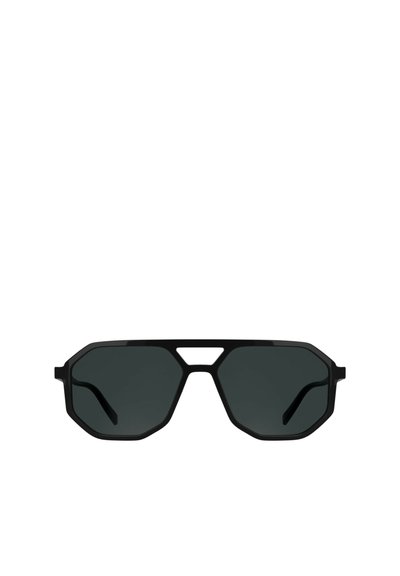 Lunettes de soleil noires octogonales avec des verres foncés, présentant un design de monture géométrique et des branches fines. Le devant comporte une découpe distinctive au niveau du pont.