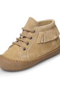 Tan semišové kotníkové boty s třásněmi vzadu, hnědá gumová podrážka a šněrování se šesti dírkami, včetně kontrastního stehu.