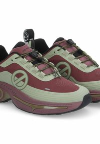 Rode en groene sneakers met een gestructureerde bovenkant, voorzien van een circulair logo, elastische veters en een gevoerde zool met een unieke vorm.