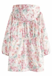 Imperméable à fleurs avec un fond rose clair, des poignets élastiqués et une capuche. Présente des détails froncés à la taille et une texture de tissu douce.