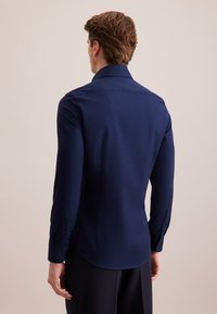 Marineblauwe lange mouwen shirt van een gestructureerde stof, met een klassieke kraag en enkelvoudige knopenmanchetten, op maat gesneden fit en een gebogen zoom.