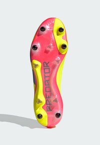 Semelle de crampon de football en rose vif et jaune, dotée de plusieurs crampons et du logo "PREDATOR", surface texturée avec une finition lisse.