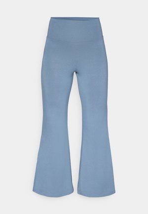 Flared yoga pants in light blue, made from stretchy fabric. High waistband and smooth texture, tapering to wider hems at the ankles.
