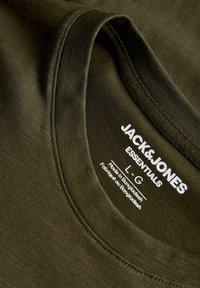 Κοντινό του ετικέτας στο λαιμό ενός σκούρου πράσινου T-shirt Jack & Jones Essentials που δείχνει μέγεθος large και κατασκευασμένο στο Μπαγκλαντές.