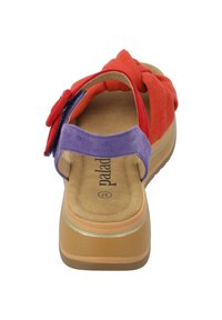 Chancla deslizante multicolor en rojo, púrpura y marrón. Presenta un material superior suave con un diseño anudado y una plantilla acolchada.