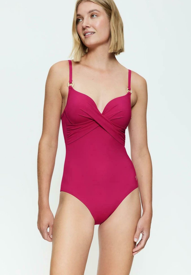 Bañador de una sola pieza fucsia con un diseño de frente retorcido, tirantes ajustables y detalles en tono dorado. Tejido suave y elástico.