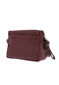 Sac en tissu bordeaux à surface texturée avec des points blancs, doté d'une poche avant et d'une bandoulière ajustable pour un transport facile.