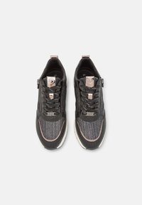 Baskets noires et grises avec une tige en mesh texturé, des coutures ton sur ton, une fermeture à lacets et zip, et un accent en or rose sur la languette. Taille 37.