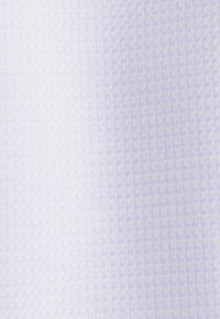 Tissu bleu clair et blanc avec un motif subtil en chevrons, montrant une fine texture de tissage diagonal sur toute la surface.