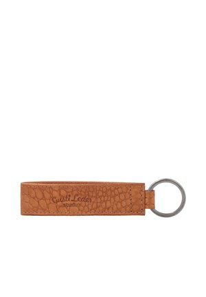 Brown textured leather keychain with a metal ring attached on the right side and "Gusti Leder studio" embossed on the leather.