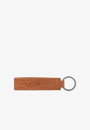 Brauner strukturierter Leder-Schlüsselanhänger mit einem Metallring auf der rechten Seite und "Gusti Leder studio" ins Leder geprägt.