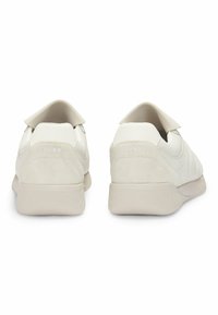 Valkoiset nahkakengät, joissa on sileä pinta ja nubuck-kohdistukset. Pyöreä takaosa, tasainen pohja ja valkoinen logo-yksityiskohta kantapäässä.