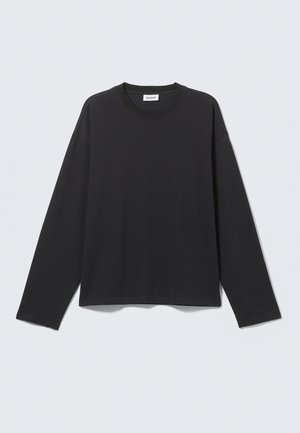 Black long-sleeve jersey top with a crew neck, relaxed fit, straight hem, and minimal stitching details. Soft texture and lightweight material.
