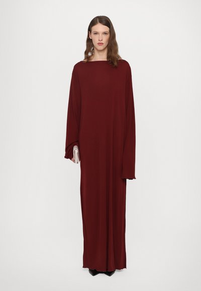 Pitkä, väljä mekko syvän burgundin värisessä kankaassa. Siinä on veneen muotoinen kaula-aukko, leveät hihat ja sileä pinta. Yhdistetty pieneen clutch-laukkuun.