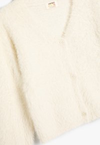 Cardigan crema testurizzato con scollo a V, realizzato in un morbido e sfocato tessuto, con tre bottoni e una vestibilità ampia. L'etichetta riporta "Koton Kids."