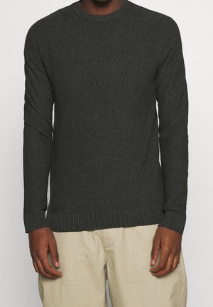 Pull en maille vert foncé avec un col ras du cou, des manches longues et des bords côtelés au niveau des poignets et de l'ourlet. Le motif texturé ajoute un intérêt visuel.