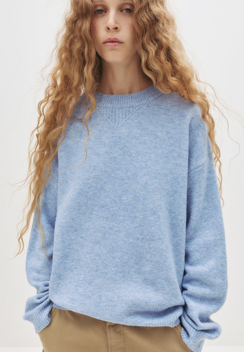 Hellblauer Strickpullover mit Rundhalsausschnitt, geripptem Saum und lockerer Passform. Verfügt über eine weiche Textur und abgesenkte Schulternähte.
