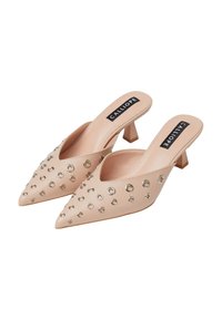 Mule beige senza lacci con punta affusolata, caratterizzate da chiodini circolari in argento, tacco basso a blocco e superiore texture liscia.