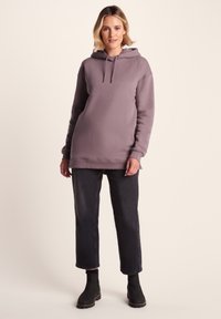 Gray pullover hoodie with adjustable drawstring, kangaroo pocket, relaxed fit, paired with dark jeans and ankle boots. Smooth texture, casual design.