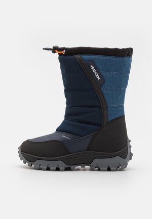 Botte d'hiver pour enfants, bleue et noire, avec une semelle épaisse et robuste, une partie supérieure rembourrée, une fermeture à cordon de serrage, et le logo Geox sur le côté.