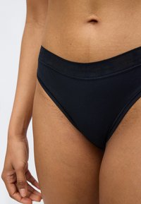 Μαύρο βαμβακερό μπικίνι εσώρουχο με ομαλή υφή και ελαστική μέση. Ο σχεδιασμός διαθέτει κανονική κοπή για άνεση και κάλυψη.