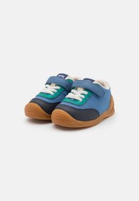 Blaue und grüne Sneaker mit strukturiertem Finish, ausgestattet mit einem Klettverschluss, weißen Schnürsenkeln und Gummisohlen mit braunen Akzenten.