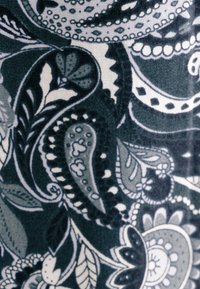 Tessuto con motivo che presenta uno sfondo verde scuro, arricchito da disegni paisley bianchi e grigi, foglie e motivi floreali. Texture liscia.