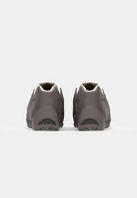 Brown athletic shoes with a textured finish, featuring a light-colored heel cap and contrasting rubber outsole. Back view with minimal detailing.