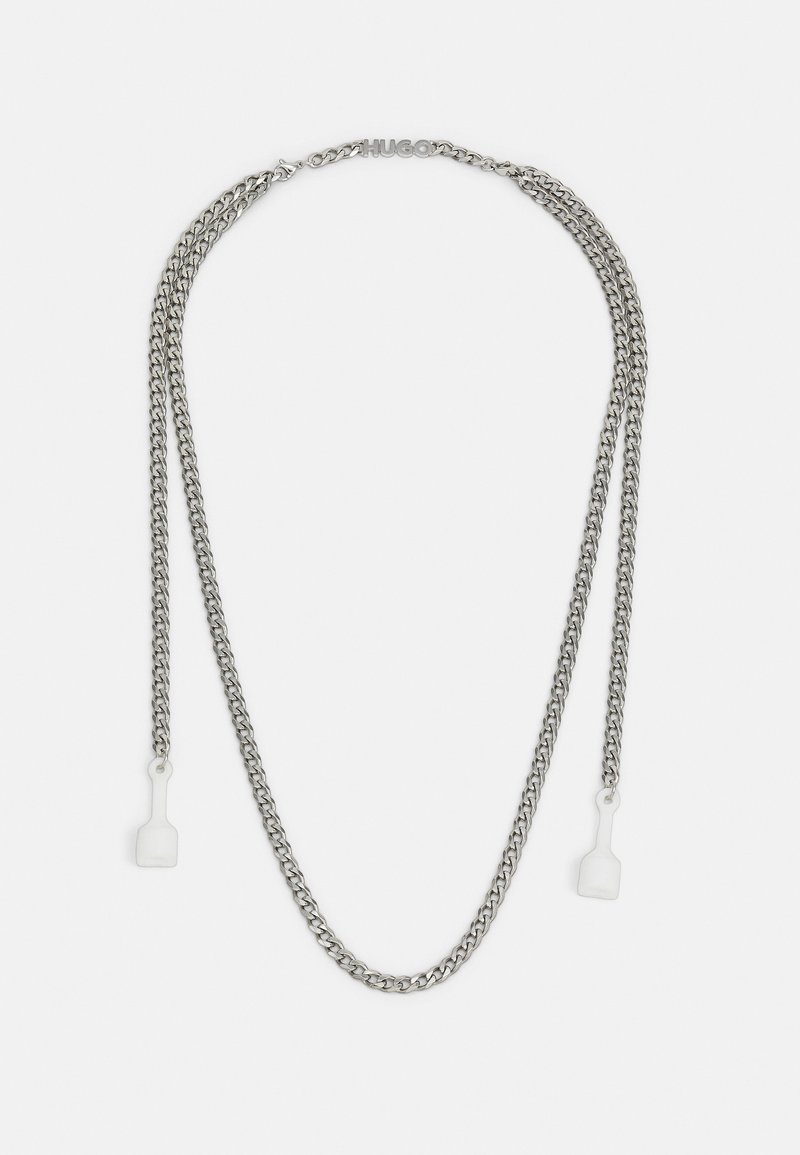 Chaîne double argentée avec logo "HUGO" sur le fermoir et embouts en plastique transparent à chaque extrémité, conçue pour tenir des lunettes ou un masque.