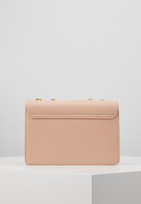 Růžová kabelka z faux kůže s sklápěcím uzávěrem, zlatým řetízkovým popruhem, obdélníkovým tvarem a hladkým povrchem. Bez viditelných vzorů nebo akcentů.