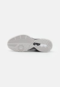 Athletic shoe outsole in white rubber, featuring textured patterns for grip, with a central circular accent and zigzag lines for flexibility.