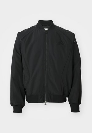 Fekete Adidas bomber dzseki elülső cipzárral, bordás gallérral, mandzsettával, aljjal, �és egy kis cipzáras zsebbel a bal ujján.