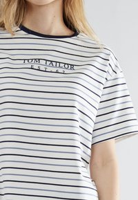 Gestreepte T-shirt in wit en marineblauw, gemaakt van zachte katoen, met een ronde hals en de tekst "TOM TAILOR EST.62" over de borst.