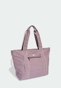 Bolso tote de nylon morado con dos asas gruesas, bolsillo frontal con cremallera y detalles en colores claros. Incluye un pequeño logotipo en la parte delantera.