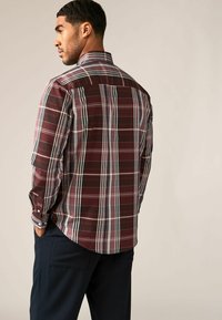 Camisa de cuadros de manga larga para hombre en color burdeos, con rayas blancas y marino, cuello tipo botón y puños ajustables. Textura de tela suave.