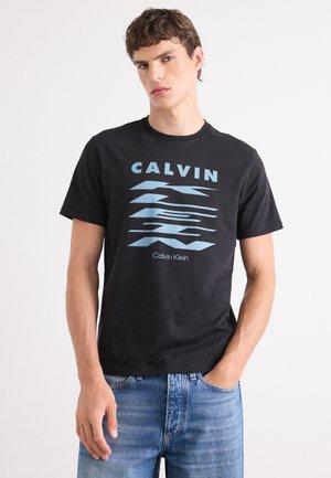 Schwarzes Baumwoll-T-Shirt mit einem hellblauen grafischen Design, das das Wort "CALVIN" und ein stilisiertes Muster zeigt. Einfacher runder Ausschnitt, kurze Ärmel.