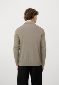 Maglione pullover marrone chiaro con colletto, maniche lunghe e polsini a coste; texture liscia e design aderente, visto da dietro.