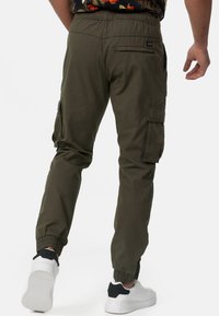 Pantalons cargo kaki en tissu léger, dotés de poignets élastiques, de poches latérales et d'une coupe décontractée. La taille est élastique pour plus de confort.
