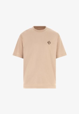 Tricou din bumbac bej, cu mâneci scurte, guler rotund și logo de marcă maro închis pe partea stângă a pieptului. Textură netedă și croială clasică.