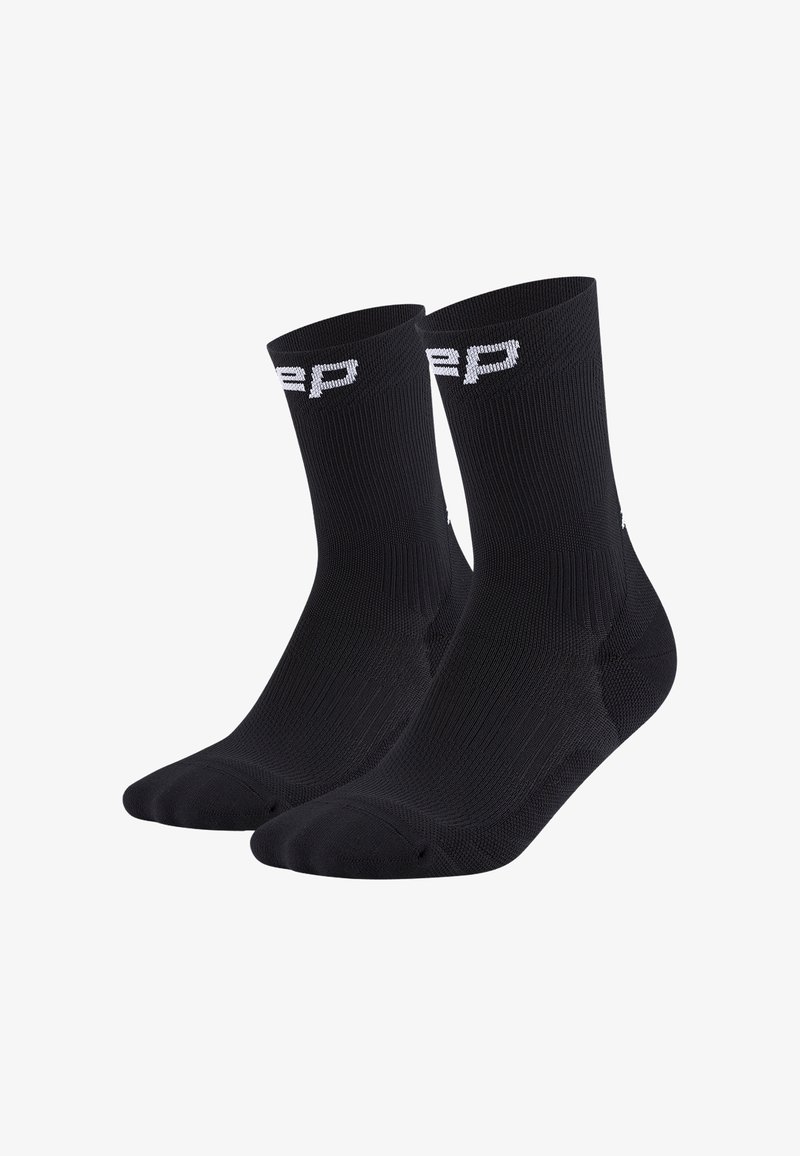 Ein Paar schwarze Crew-Socken mit weißer Beschriftung am Bund, gerippter Textur und verstärkten Fersen- und Zehenbereichen.
