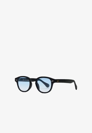 Occhiali da sole rotondi neri con lenti tinta azzurro chiaro e piccoli accenti argento agli angoli anteriori della montatura.