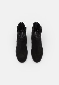 Svarta mocka ankelstövlar med en slät yta, elastiska sidopaneler och en bakre dragkedja för enkel påklädning. Robust gummisula med sömnadsdetaljer.