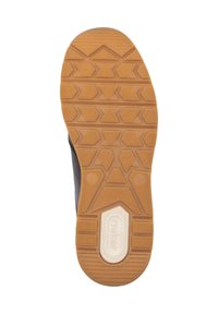 Sula på en sko med en texturerad, gummibaserad botten med ett hexagonalt mönster, beige färg och vitt logotyp i mitten.