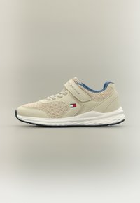 Αθλητικό παπούτσι σε ανοιχτό μπεζ με δίχτυ και συνθετικό υλικό, μπλε λεπτομέρειες, ιμάντας με βέλκρο και λευκή μεσαία σόλα με υφή από καουτσούκ στην εξωτερική σόλα.