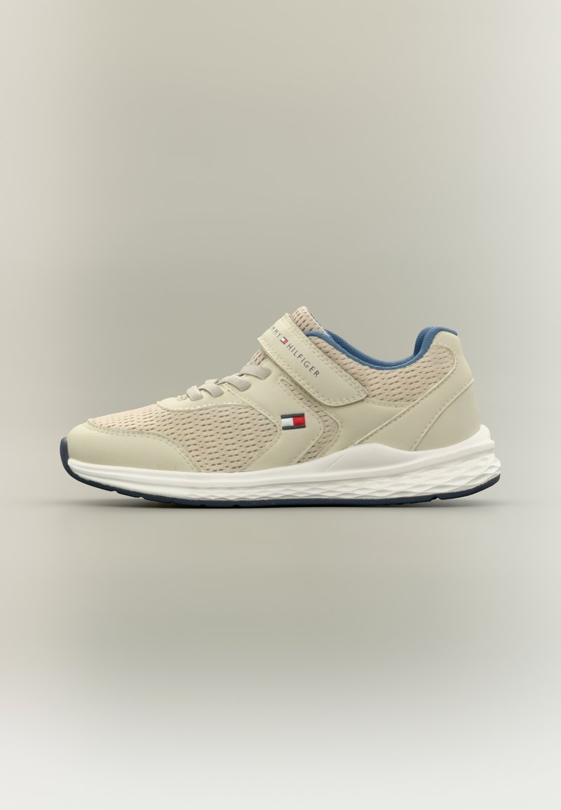 Αθλητικό παπούτσι σε ανοιχτό μπεζ με δίχτυ και συνθετικό υλικό, μπλε λεπτομέρειες, ιμάντας με βέλκρο και λευκή μεσαία σόλα με υφή από καουτσούκ στην εξωτερική σόλα.
