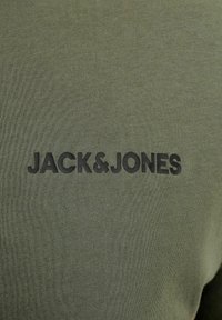 Tissu vert olive avec logo texte noir "JACK & JONES" imprimé au centre.