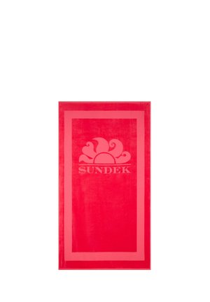 Asciugamano da spiaggia rettangolare rosso vivace con un bordo di rosso più chiaro e un logo del sole sopra la parola "SUNDEK" al centro del tessuto.