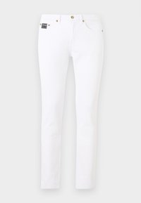 Λευκό στενό τζιν με χρυσά κουμπιά και μεταλλικά καρφιά, μπροστινές τσέπες και μικρό μαύρο σήμα μάρκας στη δεξιά πλευρά.