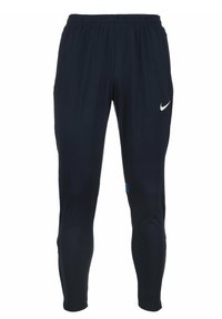 Nike Sporthosen aus dunkelblauem Stoff, mit schmaler Passform, elastischem Bund und einem weißen Logo auf der linken Hüfte. Blaue seitliche Akzente.